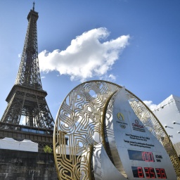 Hinter einem Counter zum Start der Olympischen Spiele ist der Eiffelturm zu sehen