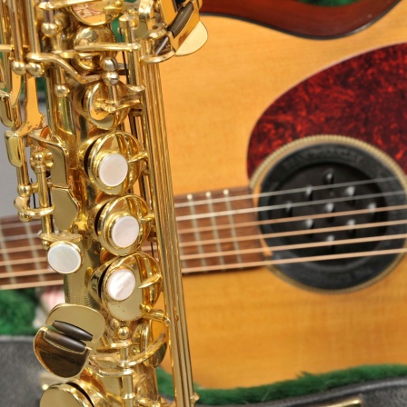Nahaufnahme von Klarinette, Akustikgitarre und Sopransaxophon.
