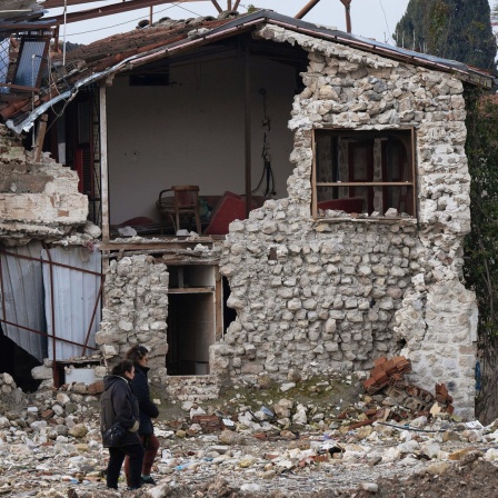 Menschen gehen im Februar 2024 in der Altstadt von Antakya (Türkei) an zerstörten Häusern vorbei.