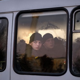 Mitglieder der ukrainischen Nationalgarde schauen aus dem Fenster, während sie in einem Bus durch Kiew fahren (Bild: dpa / Emilio Morenatti)