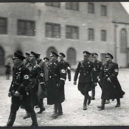 Inspektion des KZ Lichtenburg durch SS-Chef Heinrich Himmler im Herbst 1934. Auf dem Foto sind weiterhin zu sehen: der amtierende Kommandant Bernhard Schmidt, Theodor Eicke, Inspekteur der Konzentrationslager.