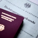 Eine deutsche Einbürgerungsurkunde und ein deutscher Pass.