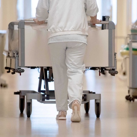 Pflegekraft schiebt Krankenbett über Krankenhausflur (Bild: picture alliance/dpa/Marijan Murat)