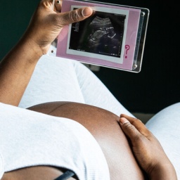 Ein schwangere Frau schaut auf das Ultraschallbild ihres Babys.