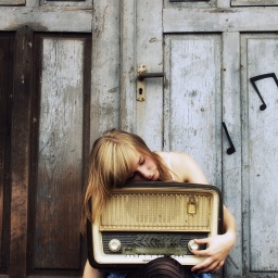 Eine Frau umarmt ein altes Radio.