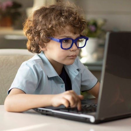 Junge mit Brille sitzt dicht vor einem aufgeklappten Laptop: Augenerkrankungen nehmen weltweit deutlich zu. Zwei Drittel aller Deutschen benötigen bereits eine Sehhilfe. Bei jungen Menschen steigt vor allem die Zahl der Kurzsichtigen.