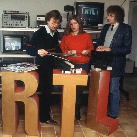 Produktionsleiter Horst Tempel, Musikkoordinatorin Angelika Schimpf und Moderator Ilf Bennet bei einer Arbeitsbesprechung in der Luxemburger Sendezentrale von RTL im Dezember 1983