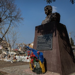 An der Statue des ukrainischen Lyrikers und Malers Taras Schewtschenko ist sein Gedicht "Liebe deine Ukraine, liebe sie ... Während der Wut, im letzten schwierigen Moment. Betet für sie.'' vor den Trümmern eines zerstörten Hauses in Kiew Oblast zu lesen.