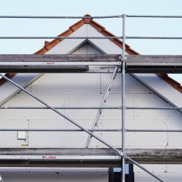 Ein Gerüst steht vor einem Neubau. Symbolbild