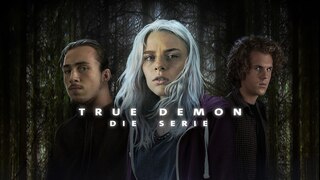 In der Mitte eine junge Frau mit silbrigen Haaren, links und rechts von ihr je ein junger Mann, im Hintergrund ein dichter Nadelwald, im Vordergrund der Schriftzug "True Demon - Die Serie"