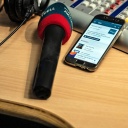 Ein Mikrofon von MDR AKTUELL im Studio, daneben ein Handy/Smartphone