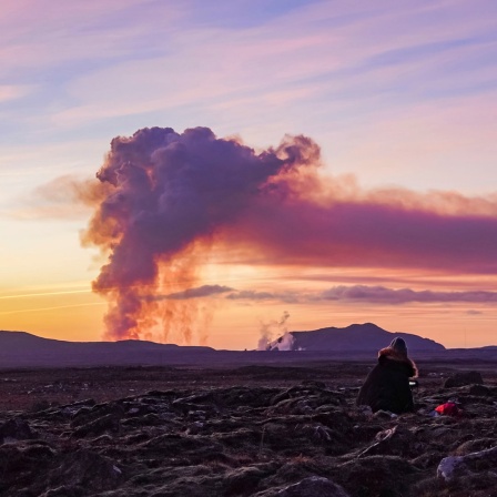 Menschen beobachten von Norden aus den Ausbruch des Vulkans in der Nähe von Grindavik. 