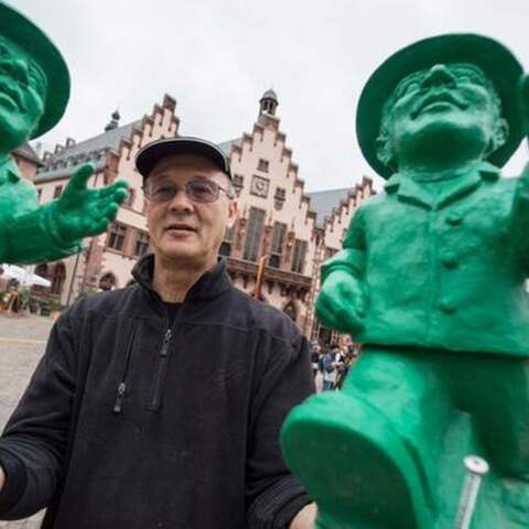 Ottmar Hörl steht am 07.09.2015 in Frankfurt am Main (Hessen) auf dem Römerberg mit zweien seiner &#034;Einheitsmännchen&#034; in den Händen