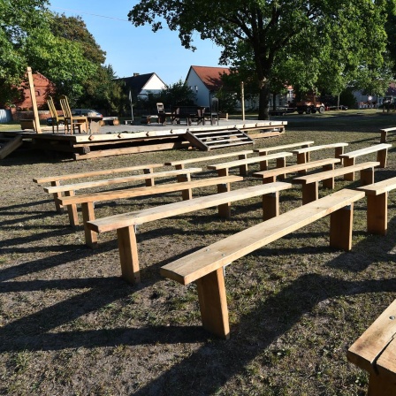 Theaterbühne und Bänke sind am 22.09.2016 in Garlitz (Brandenburg) aufgebaut. Holzbänke stehen vor einer Bühne auf einer Wiese.