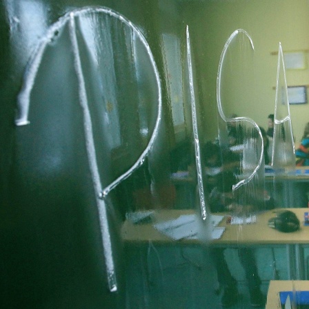 Die Wörter "PISA" steht an einer Tafel, während Schüler den Unterricht verfolgen.