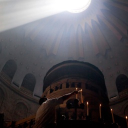 Ein Lichtkegel fällt von oben in die Grabeskirche in Jerusalem.