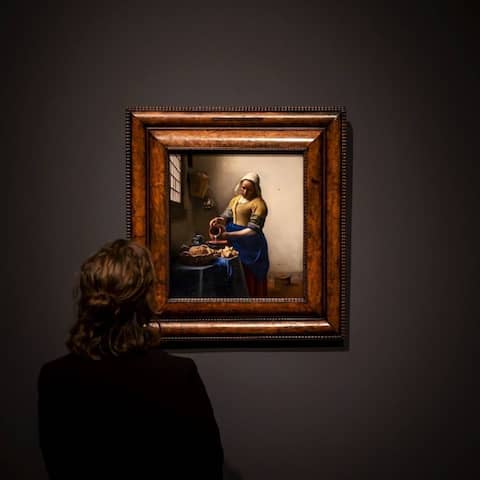 Eine Frau blickt auf ein Bild von Jan Vermeer (Foto: imago images / ANP)