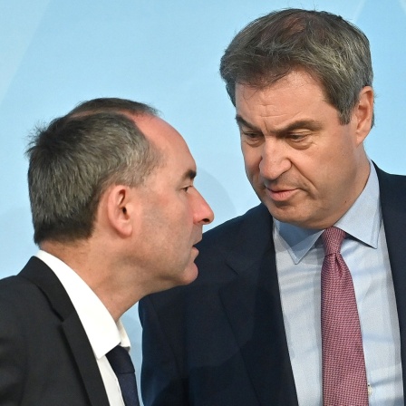 Der bayerische Wirtschaftsminister Hubert Aiwanger und Bayerns Ministerpräsident Markus Söder besprechen sich vor einer Pressekonferenz.