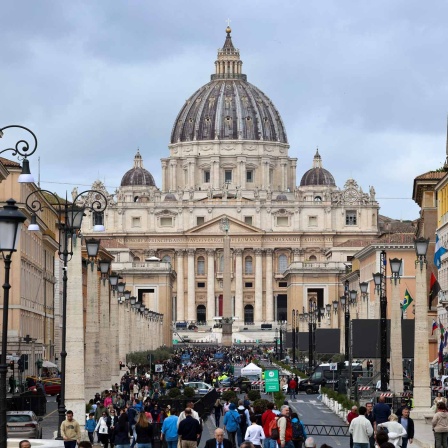 Blick auf den Petersdom über die Via della Conciliazione, tausende Menschen gehen in Richtung des Vatikans.