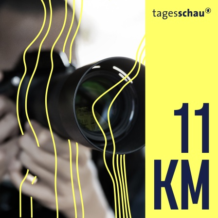 Ein Mann mit Kamera und Teleobjektiv.