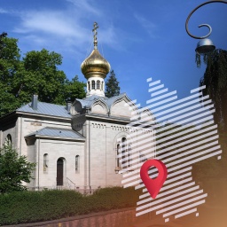 Die russisch-orthodoxe Kirche von Baden-Baden steht an einer Straßenkreuzung unter alten Bäumen. 
