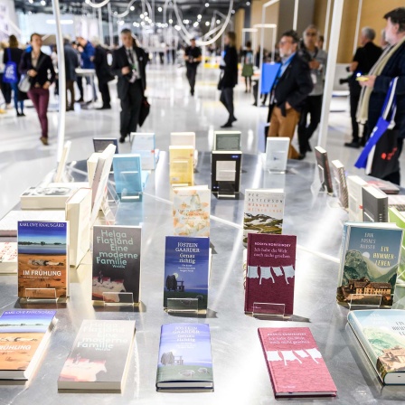 Menschen gehen durch den Gastlandpavillon Norwegens auf der Frankfurter Buchmesse. Im Vordergrund werden Bücher von norwegischen Autoren ausgestellt.© dpa/Silas Stein