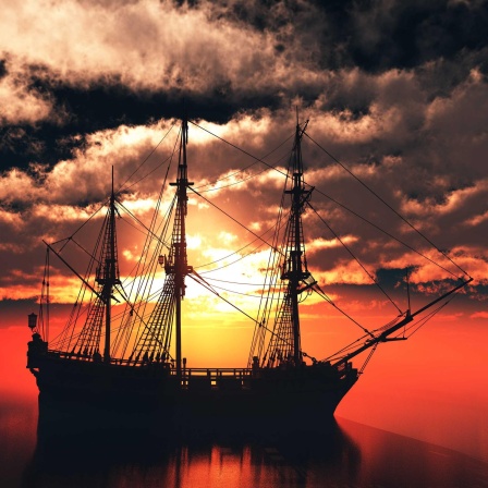 Silhouette eines alten Segelschiffs im Meer vor rotem Sonnenuntergang.