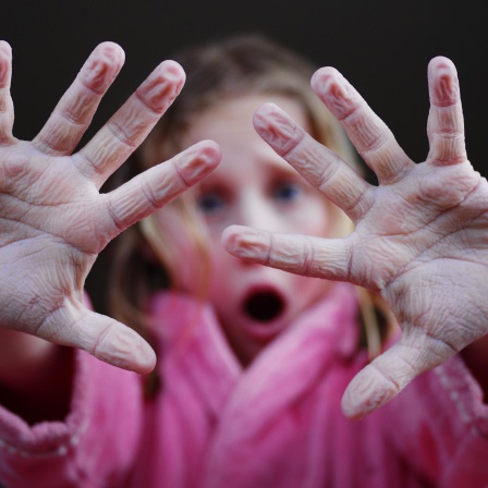 Mädchen hält schrumpelige Finger hoch