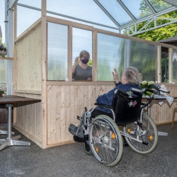 Barbara Fabian besucht am Freitag, 08.05.2020, ihre 87-jährige Mutter Irene Termin im Franziskushaus in Mülheim an der Ruhr. Dabei sind die beiden auf der Terrasse des Hauses durch einen Holzzaun und Plexiglasscheiben getrennt.