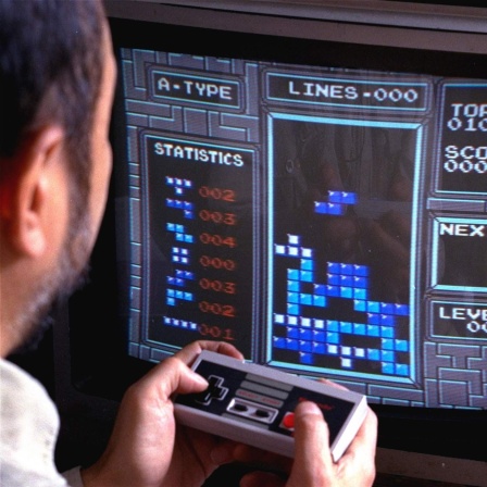 Ein Mann spielt Tetris auf einer Nintendo Konsole.