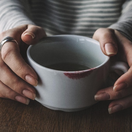 MIDSECTION OF WOMAN WITH COFFEE CUP