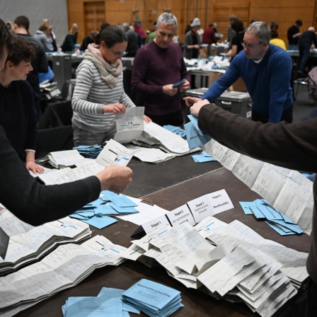 Wahlhelfer arbeiten während der Auszählung der Briefwahlstimmen in der Max-Schmeling-Halle in Berlin.