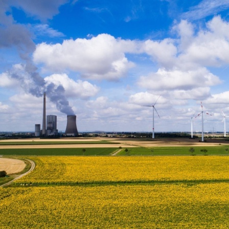 Ein Sonnenblumenfeld steht in Sichtweite vom Kohlekraftwerk Mehrum, Windrädern und Hochspannungsleitungen im Landkreis Peine (Luftaufnahme mit Drohne).