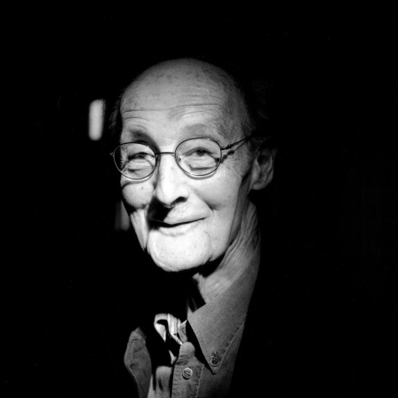 Schwarz-weißes Portaitfot von André Gorz vor dunkelm Hintergrund.