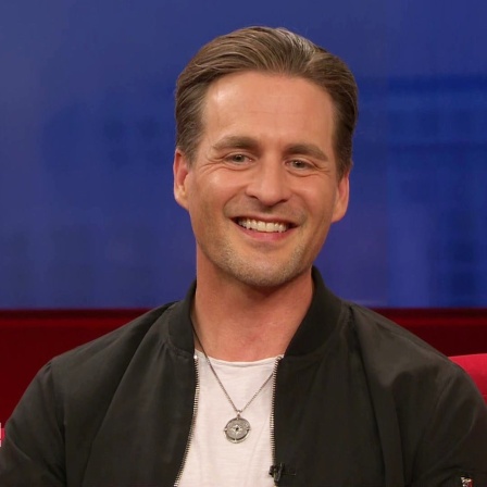 Alexander Klaws auf dem roten Sofa.