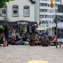 In der Innenstadt von Westerland auf Sylt sitzen viele Punks. Sie haben Rücksäcke und Hunde bei sich.