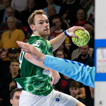 Der Handballer Mathias Gidsel setzt einen Wurf auf das gegnerische Tor ab.