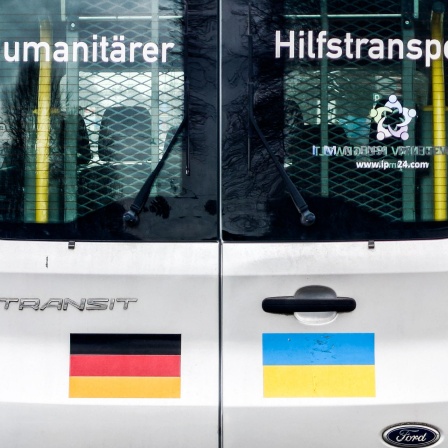 Die Rückseite eines Transporters für humanitäre Hilfe aus Deutsch, die für die Ukraine bestimmt ist. Auf die Tür des Fahrzeugs sind Aufkleber mit deutscher und ukrainischer Flagge und der Schriftzug "Humanitärer Hilfstransport".