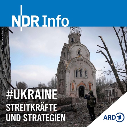 Ein ukrainischer Soldat fotografiert eine beschädigte Kirche nach dem Beschuss eines Wohnviertels. 