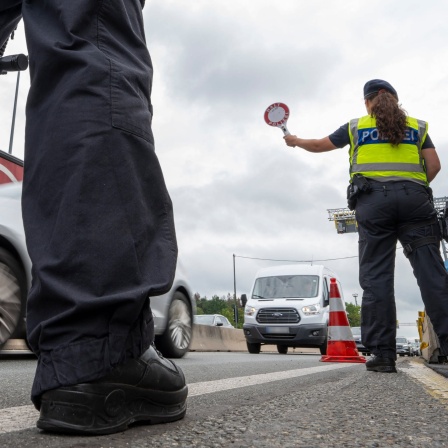 Polizisten stehen bei Grenzkontrollen der Bundespolizei am Grenzübergang zwischen Österreich und Deutschland an der Autobahn A8 nahe Salzburg