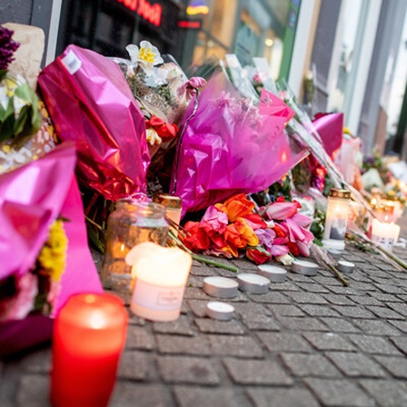 Zahlreiche Blumen und Kerzen stehen in der Oldenburger Innenstadt an einer Hauswand.