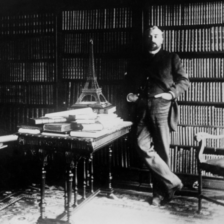 Gustave Eiffel, franz. Ingenieur, in seiner Bibliothek neben einer Eiffelturm-Miniatur um 1900.