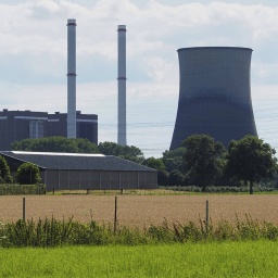 Gaskraftwerk hinter einem Feld und Bäumen
