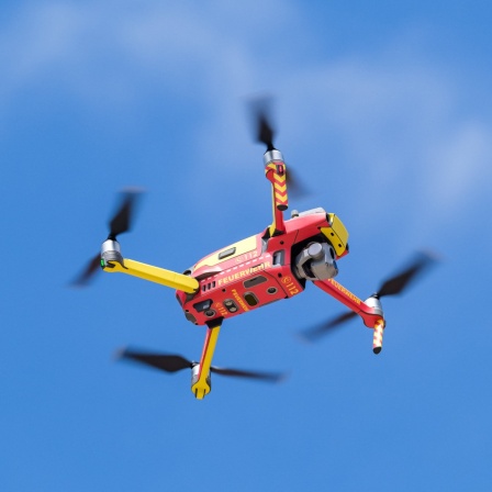 Eine Drohne der Feuerwehr Hannover fliegt am blauen Himmel