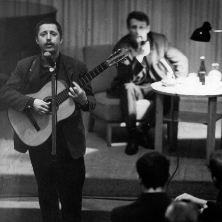 Großen Beifall fanden die Lieder des Studenten Wolf Biermann, im Hintergrund der Schriftsteller Stephan Hermlin, beim Lyrikabend in der Berliner Akademie der Künste im Dezember 1962. 