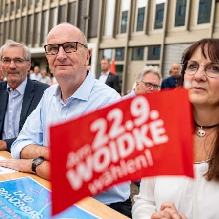 Brandenburgs Ministerpräsident Dietmar Woidke sitzt beim SPD-Sommerabend 2024 in Potsdam zusammen an einem Tisch mit dem früheren Regierungschef Matthias Platzeck und Finanzministerin Katrin Lange.