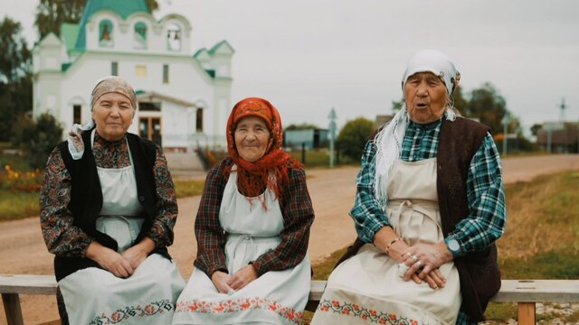 Drei alte Frauen vor einer russischen Kirche.