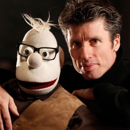 Detlef Wutschik hält seine Klappmaulpuppe "Werner Momsen" im Arm.