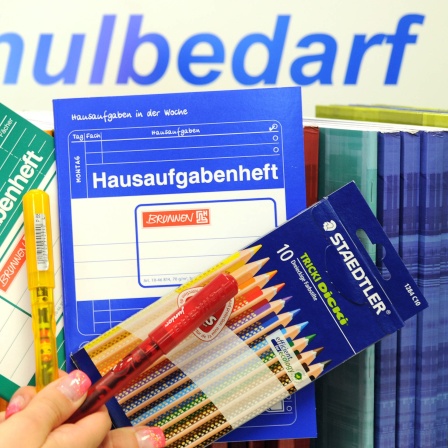 Arbeitshefte, Füller und Buntstifte, fotografiert in einem Geschäft mit Schulbedarf
