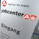 Ein Kunde geht durch die Tür eines Jobcenters.